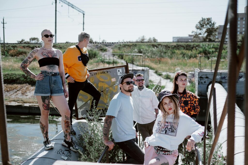 pexels-photo-5238215-5238215 Fashionable group posing in streetwear by an industrial outdoor area.