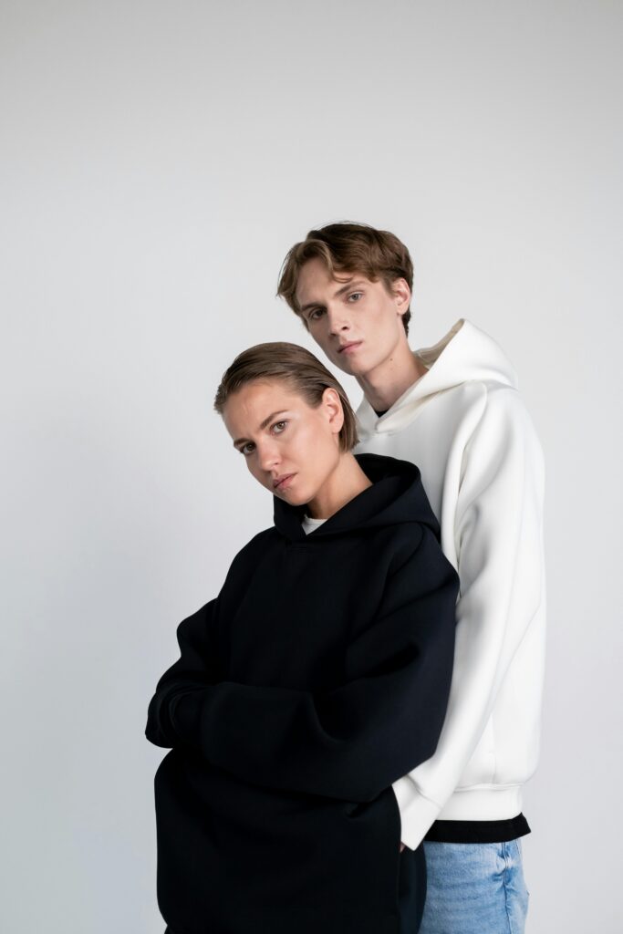pexels-photo-8346261-8346261 Stylish portrait of a man and woman in casual hoodies against a white background.